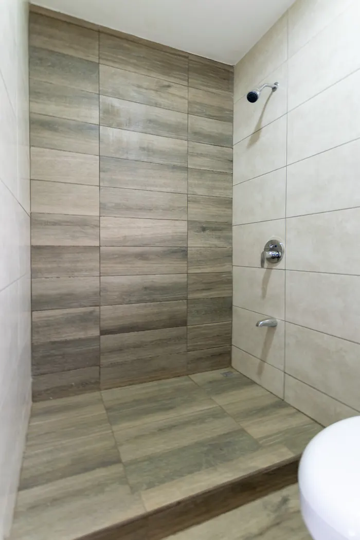 Baño con ducha enchapada en cerámica tipo madera